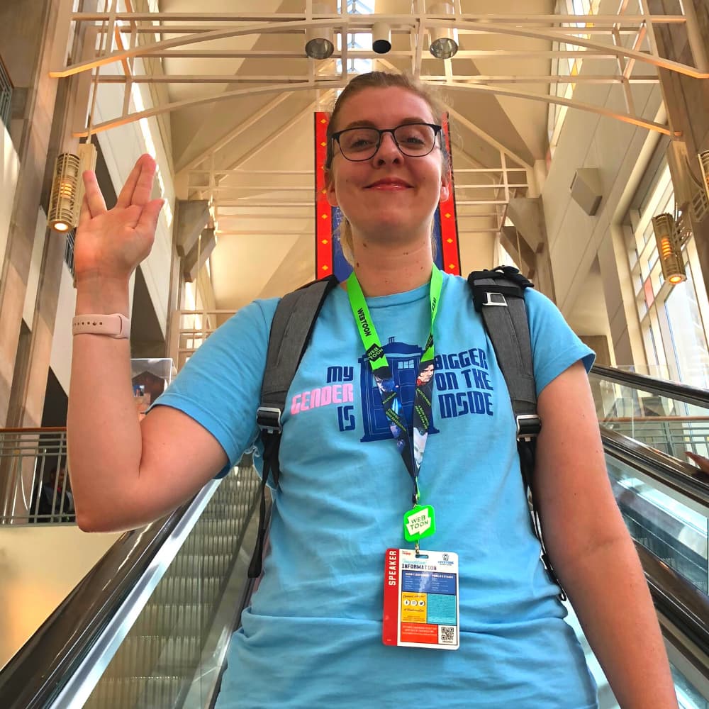 Larisa Garski gives the Vulcan salute while riding an escalator at Comic-Con.
